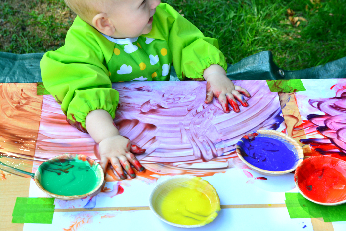 Baby playing with paint outside