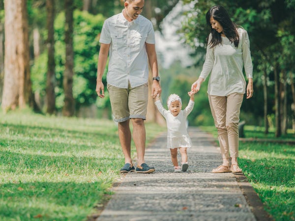 Parents taking their child for a walk in the park