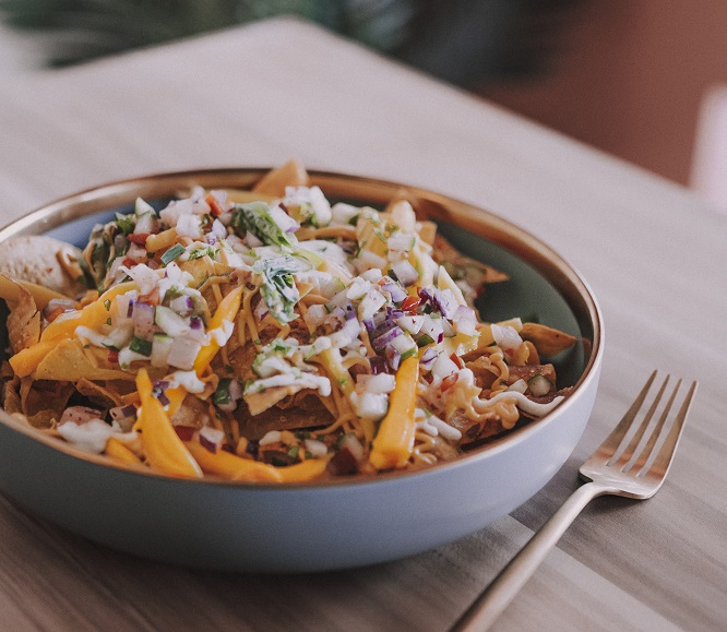 Nacho Regular Jack- Shredded jackfruits within a pile of nachos, topped with Asian salsa, guacamole, sour cream, and cheese sauce