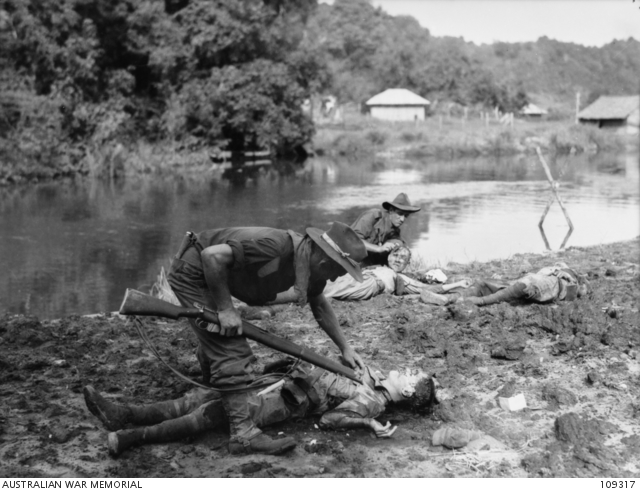 Australian troops inspecting the bodies of dead Japanese soldiers