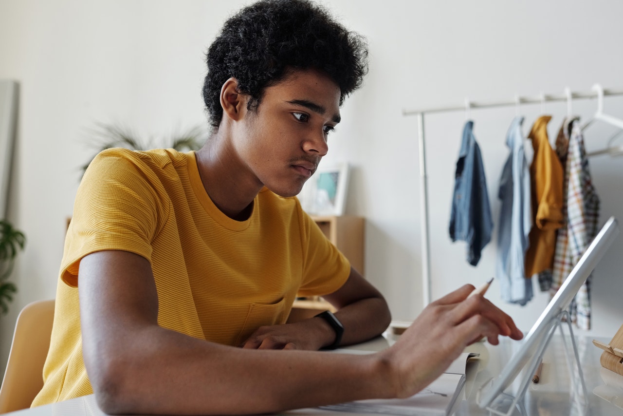 man-in-yellow-crew-neck-t-shirt-while-using-tablet-4144096