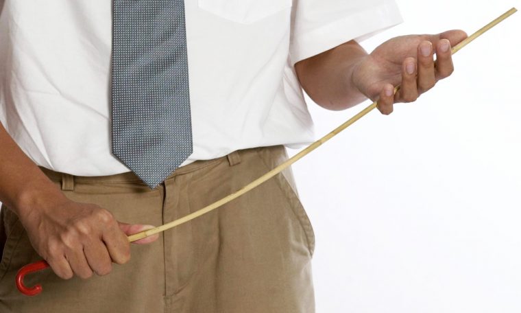 Man in a suit holding a cane 