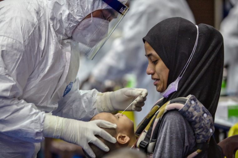 a child getting a swab test in Kuala Lumpur