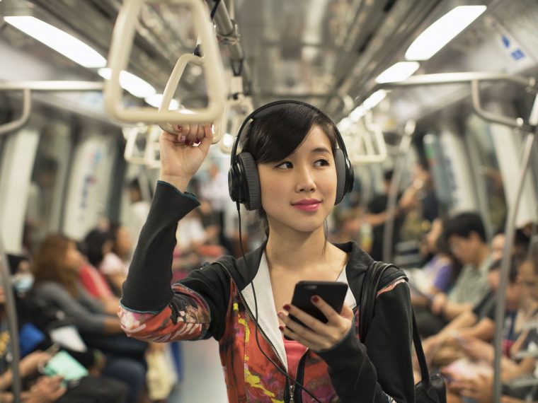 Asian lady listening to music on the train