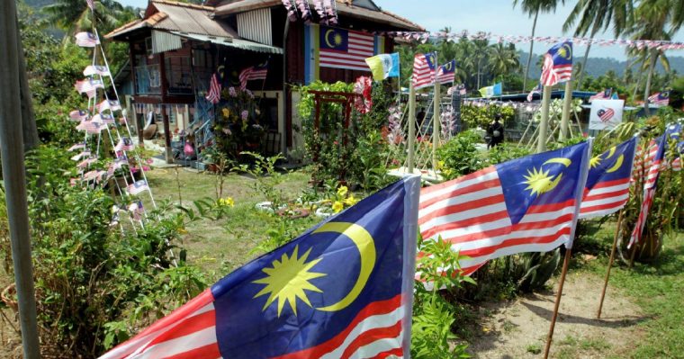 A house covered in jalur gemilang flags 