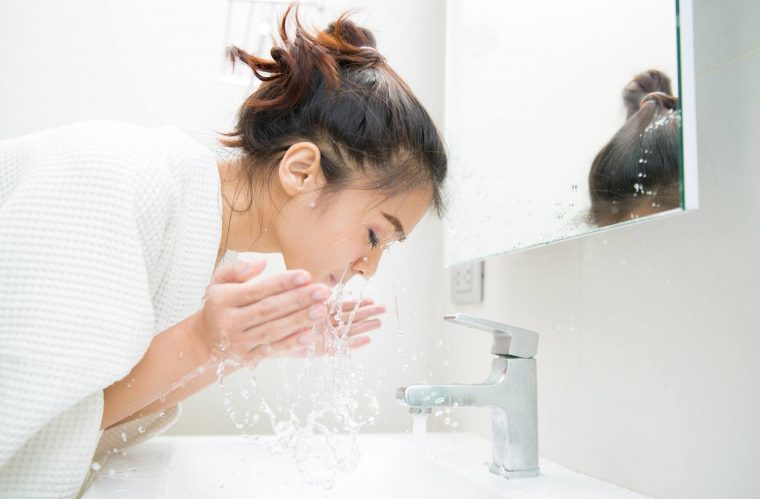 woman splashing water on her face