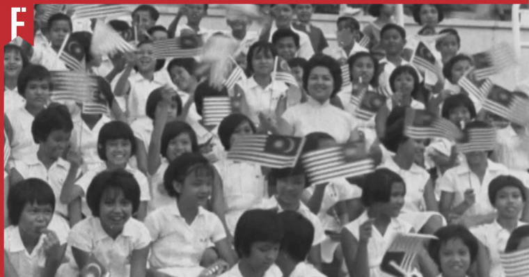 excited children waving the flag of Malaysia for the first time