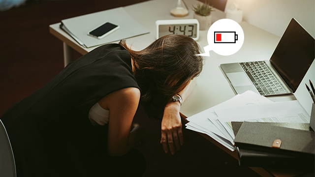 a woman stressed out from work, laying her head on the table