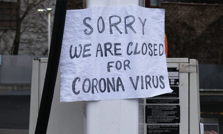 A sign at a window saying "Sorry We Are Closed For Corona Virus"