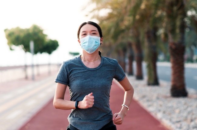 masked woman jogging outside