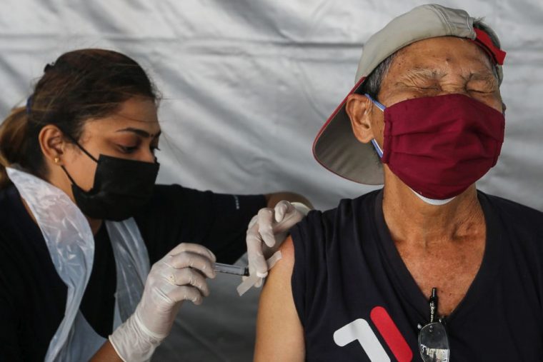 old man getting a vaccine jab in Malaysia