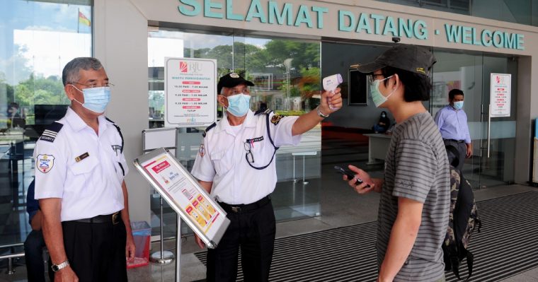 security guards working and taking visitor temperature