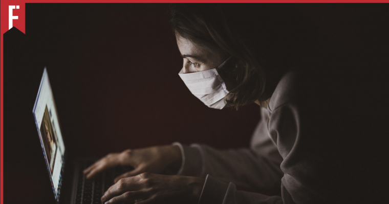 girl hunched over in the dark staring at a computer screen