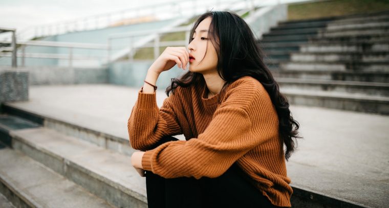 Girl sitting on the stairs looking glum