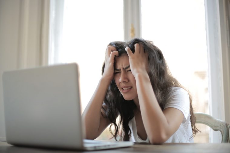 stressed woman sitting alone in front of a computer
