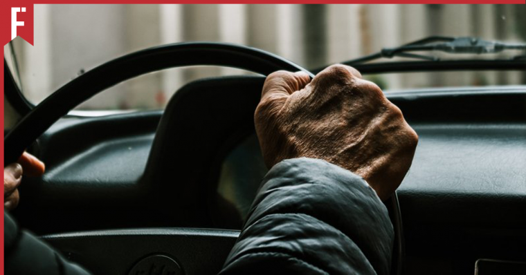 elderly man driving a car