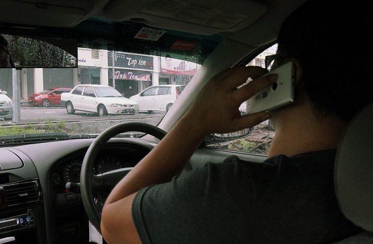 man chatting on mobile phone while driving