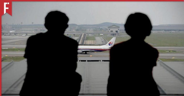 people looking out airport window