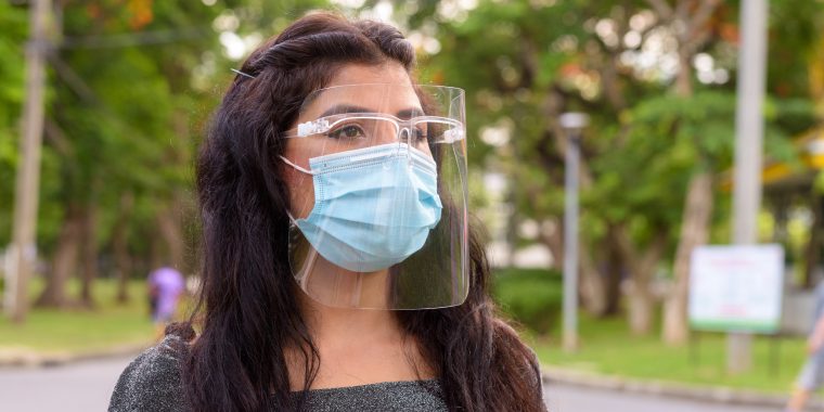 A lady wearing a mask and face shield