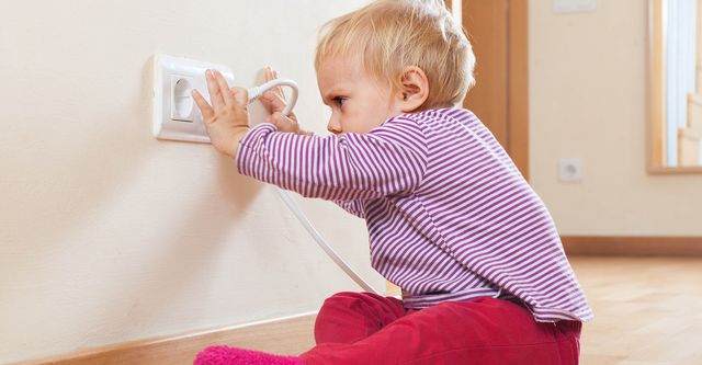 baby playing with plug