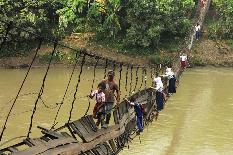 kids going on suspension bridge that's broken to get to school